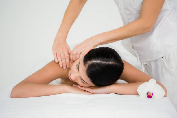 istock Pretty brunette enjoying a massage with flower 667341140