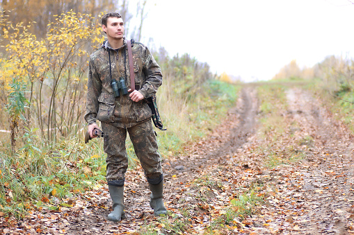 man hunter outdoor in autumn forest hunting alone