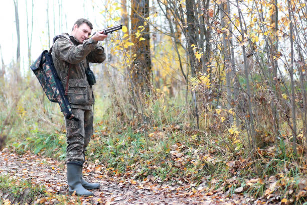 man hunter outdoor in autumn forest hunting alone