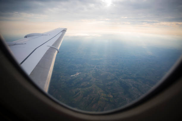 Clouds and earth seen through window of airplane
