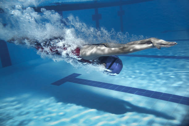 istock swimmer jump from platform jumping a swimming pool.Underwater photo 667343682