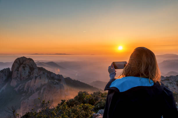 istock Young woman taking a sunset with her phone 667346254