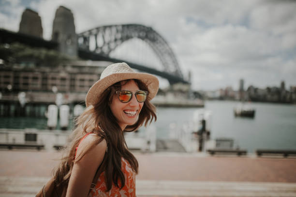 femme souriante heureuse découverte de sydney, avec le pont du port à l’arrière-plan. - sydney australia photos et images de collection