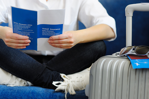 Woman with the suitcase goes on a journey. Read Travel insurance. I checked the font license, I'm 100% sure.