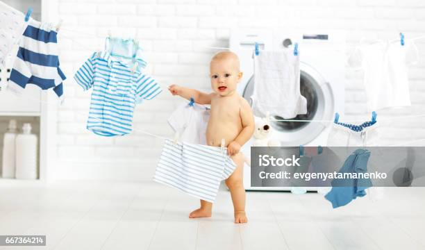 Fun Happy Baby Boy To Wash Clothes And Laughs In Laundry Stock Photo - Download Image Now