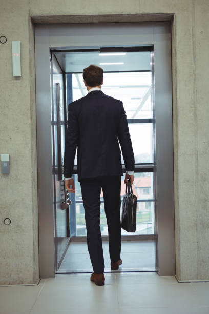 istock Rear view of businessman walking into an elevator 667365108