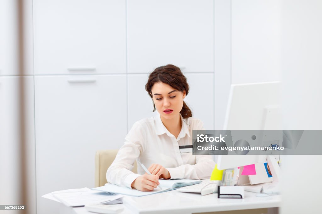 friendly young woman behind the reception desk administrator Receptionist Stock Photo