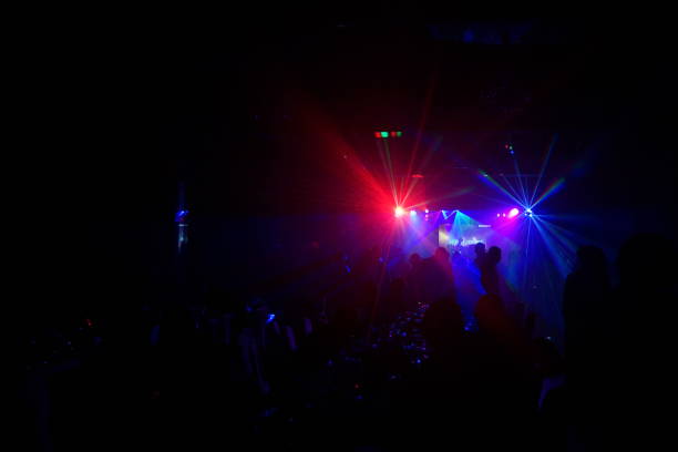 istock cheering crowd in front of bright stage lights 667365390