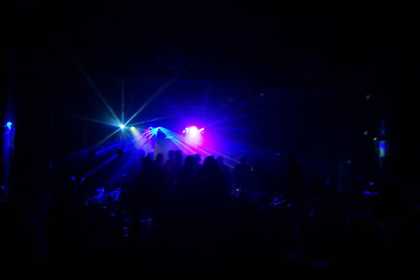istock cheering crowd in front of bright stage lights 667365618