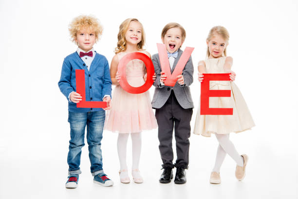 Four beautiful little kids holding word love on white