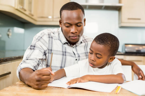 Father helping son for homework Father helping son for homework in the kitchen short weave hairstyles stock pictures, royalty-free photos & images