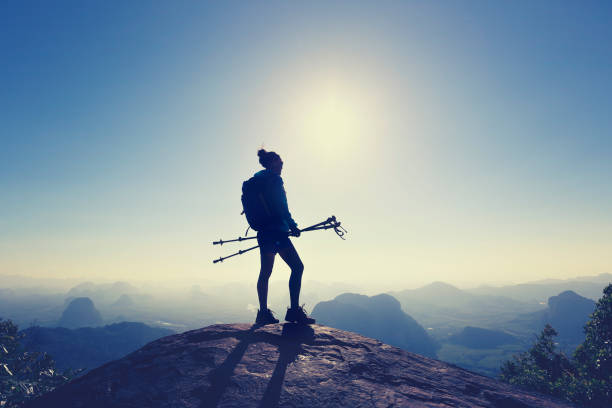 istock successful woman backpacker hiking on sunrise mountain top 667375038