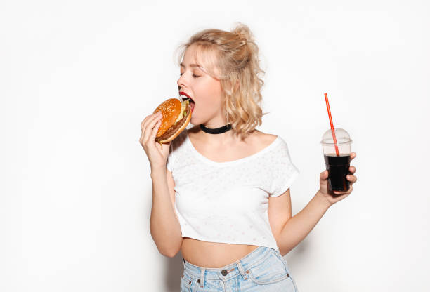 istock Pretty young girl with cola and burger 667375248