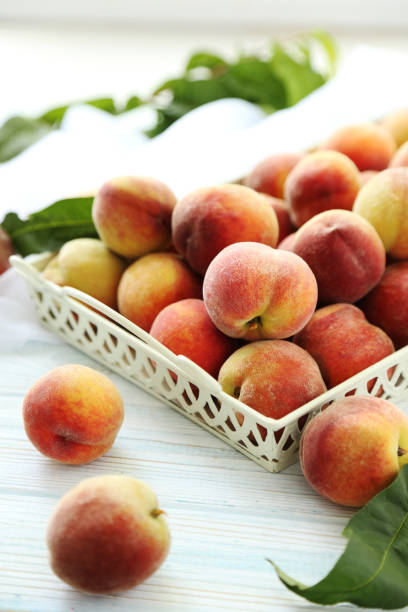 istock Sweet peach fruit in tray on white wooden table 667375520
