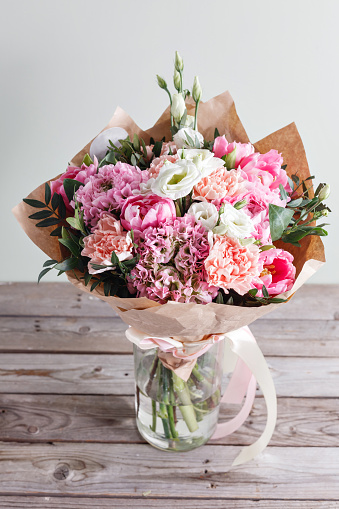 Beautiful bouquet of flowers against wooden background. Vintage styled.