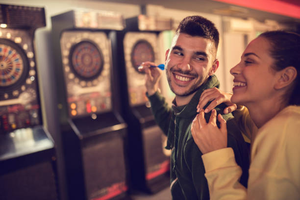 istock Happy couple playing darts in a pub and having fun together. 667380462