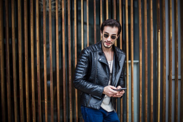 istock Man in biker jacket standing by the fence 667384618