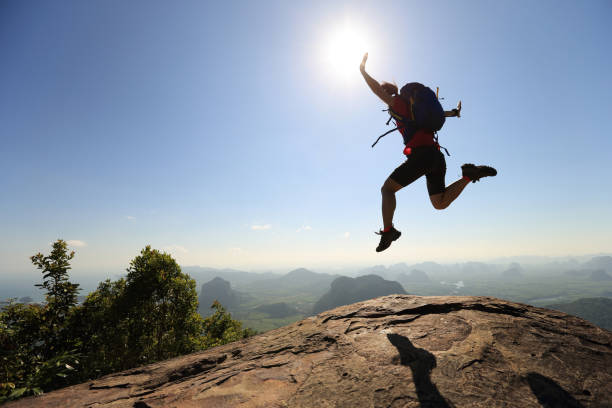 istock freedom woman backpacker jumping on sunrise mountain top 667394862
