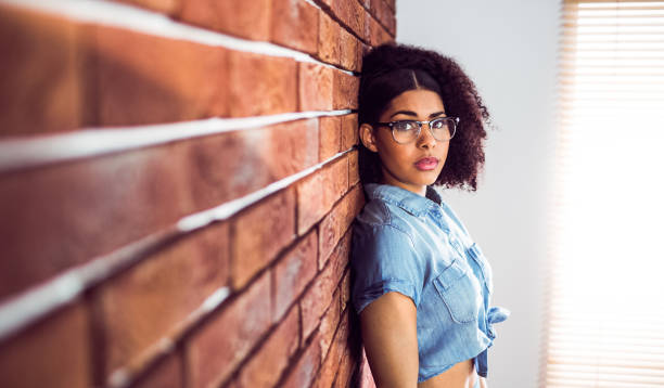 istock Attractive hipster leaning against red brick background 667395058