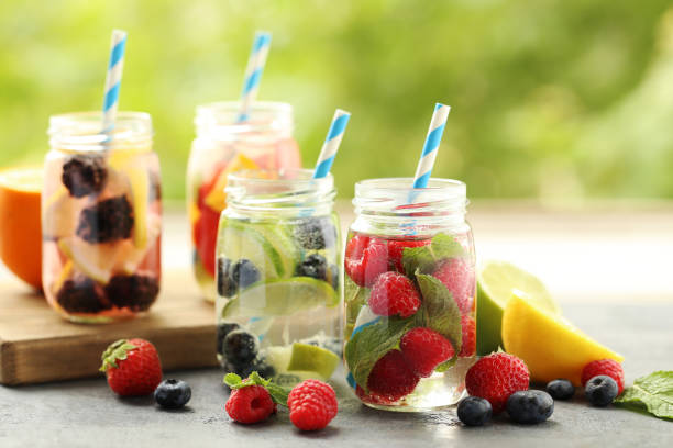 istock Detox water in bottles with berries on wooden table 667397270