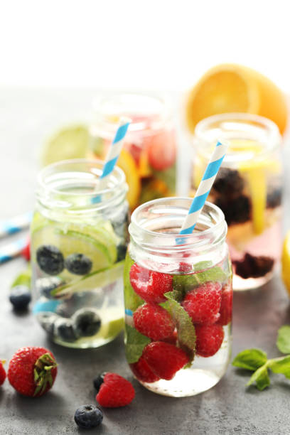 istock Detox water in bottles with berries on wooden table 667399372