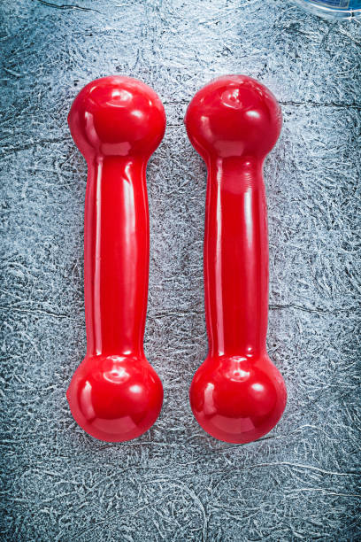 istock Red dumb-bells on silver background horizontal version fitness c 667409178