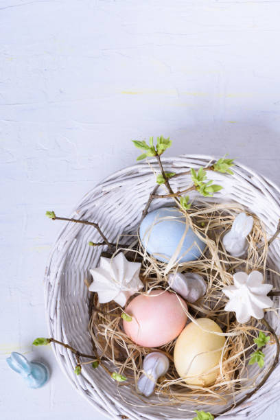 istock Easter eggs painted with delicate pastel color in a woven round basket, white background. Spring holiday. 667409862