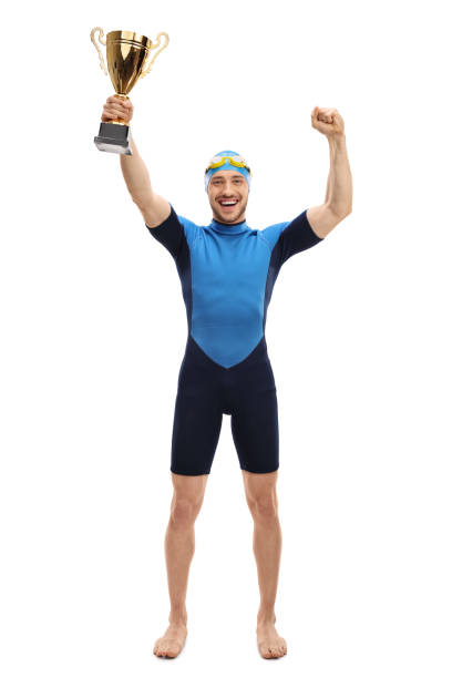 istock Overjoyed swimmer holding a gold trophy and gesturing happiness 667409878