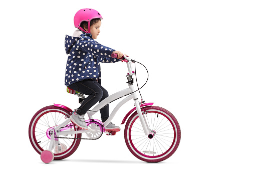 Cute little girl riding a bike isolated on white background