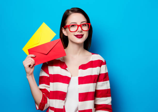 istock smiling woman with two envelopes 667412782