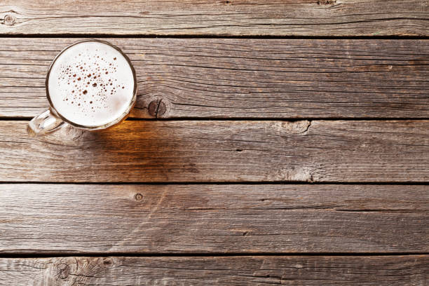 Beer mug on wooden table Beer mug on wooden table. Top view with copy space pub table top view stock pictures, royalty-free photos & images