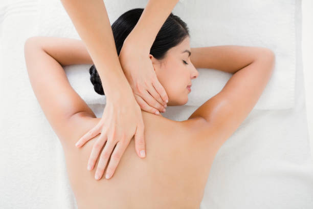 Woman receiving a back massage Upward view of woman receiving back massage at spa center massage therapist stock pictures, royalty-free photos & images