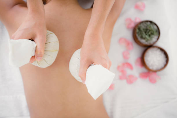 istock Pretty woman enjoying a herbal compress massage 667421672