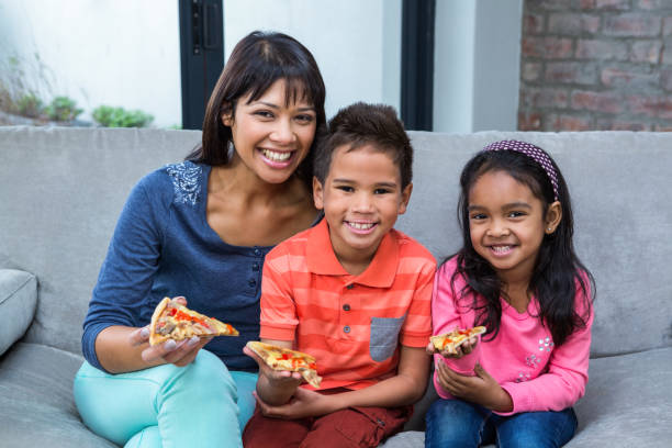 istock Happy  family eating pizza on the sofa 667421934