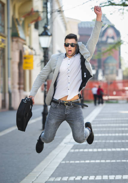 istock Business man with suitcase jumping on walking street 667422016