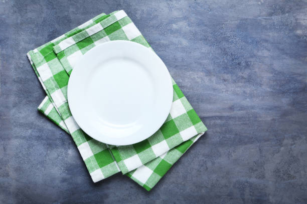 istock Empty plate with napkin on grey wooden table 667422306