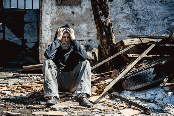 Destroyed house Portrait of homeless man on ruins of his house tramp home stock pictures, royalty-free photos & images