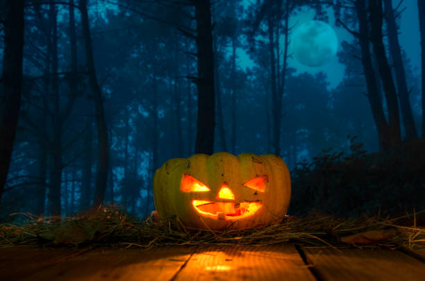 istock Halloween Pumpkins On Wood In A Spooky Forest At Night 667425568