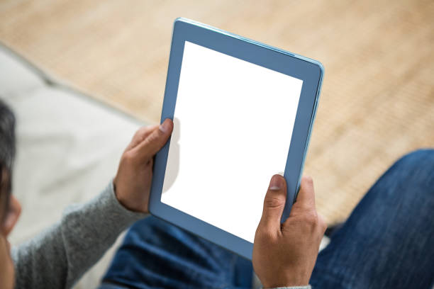 istock Handsome man using tablet on the sofa in living room 667425672