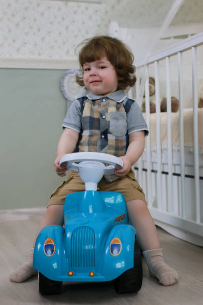 istock litle boy sit on a toy car 667426010
