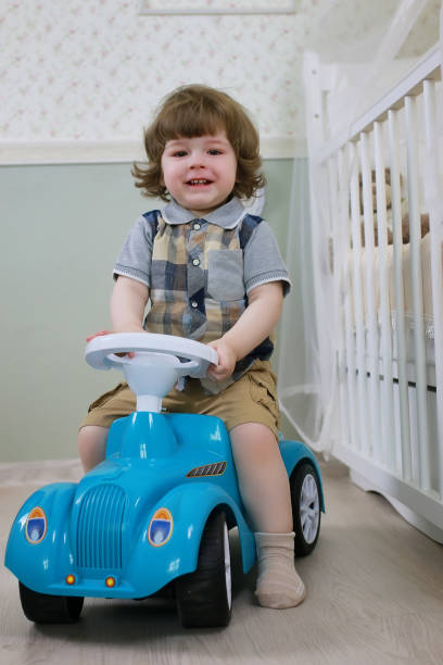 istock litle boy sit on a toy car 667426076
