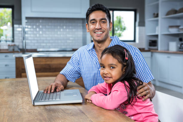 istock Smiling father using laptop with his daughter 667427142
