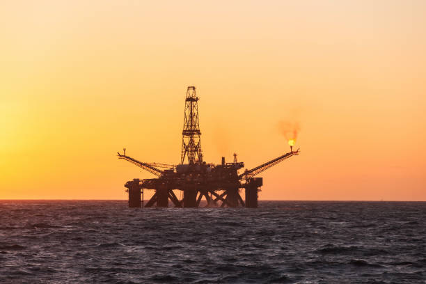 Offshore jack up rig in the middle of the sea at sunset time stock photo