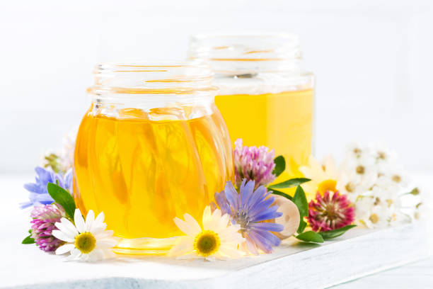 istock jars with fresh flower honey on white background 667431476
