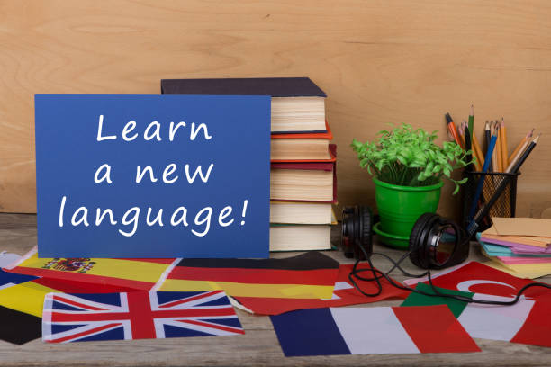 テキスト「学ぶ新しい言語!」、フラグ、書籍、ヘッドフォンの紙 - text talking translation learning ストックフォトと画像