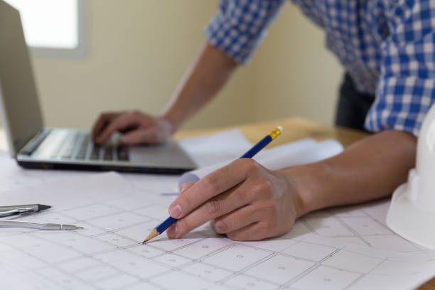 istock Architect or engineer working with blueprints and laptop in office, Construction concept. 667439048