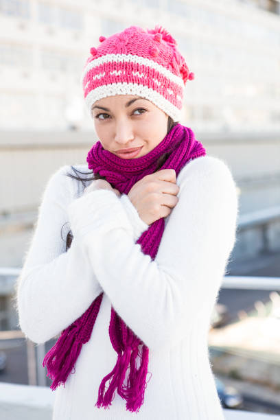 Smiling woman wearing a scarf and hat outside