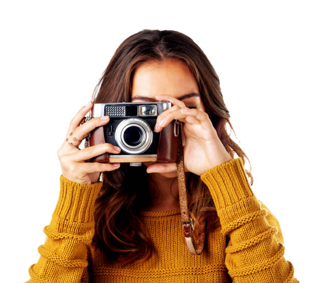 Studio shot of a young woman holding up her camera