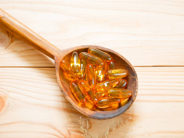 istock Fish oil capsules on wooden spoon 667442424