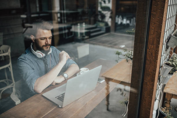 istock A businessman in thought while using laptop and drinking coffee at the cafe 667450044